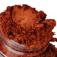 Eyeshadow copper-gold metallic shimmer in a jar, close-up view, glittery texture