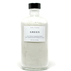 Facial cleansing grains in a clear glass bottle with black cap, ANITAKO ORGANICS label