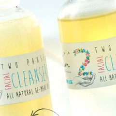 Facial cleanser bottles with yellow liquid, white labels, and floral design with Elixirium text
