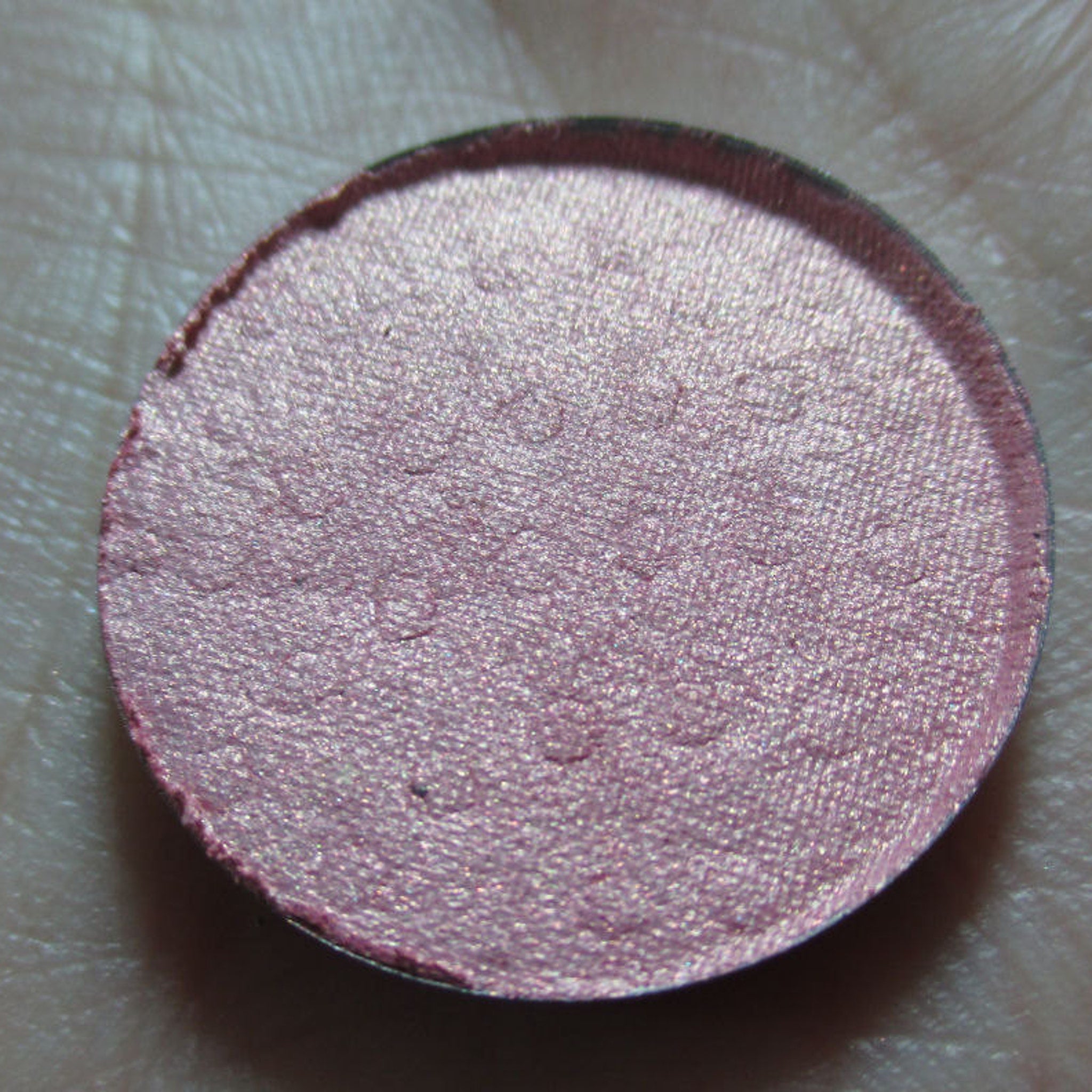 Petal Soft Eye Shadow in a round compact with smooth matte pink casing and shimmering neutral-toned powder.