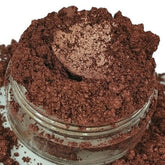 Eyeshadow makeup in copper rose color with shimmer and powder texture in a clear jar
