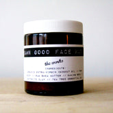 Facial cleanser jar with white lid and black label, "Damn Good Face Wash" by the works