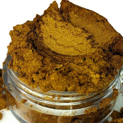 Gold powder in a clear glass jar, showing granular texture and golden color
