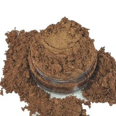 Brown powder with glitter particles in clear jar, surrounded by loose powder