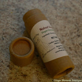 Lip balm tube with brown cardboard, white label, and Naked Pug text visible