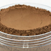 Vegan mineral powder foundation, dark brown powder, clear jar, layered texture