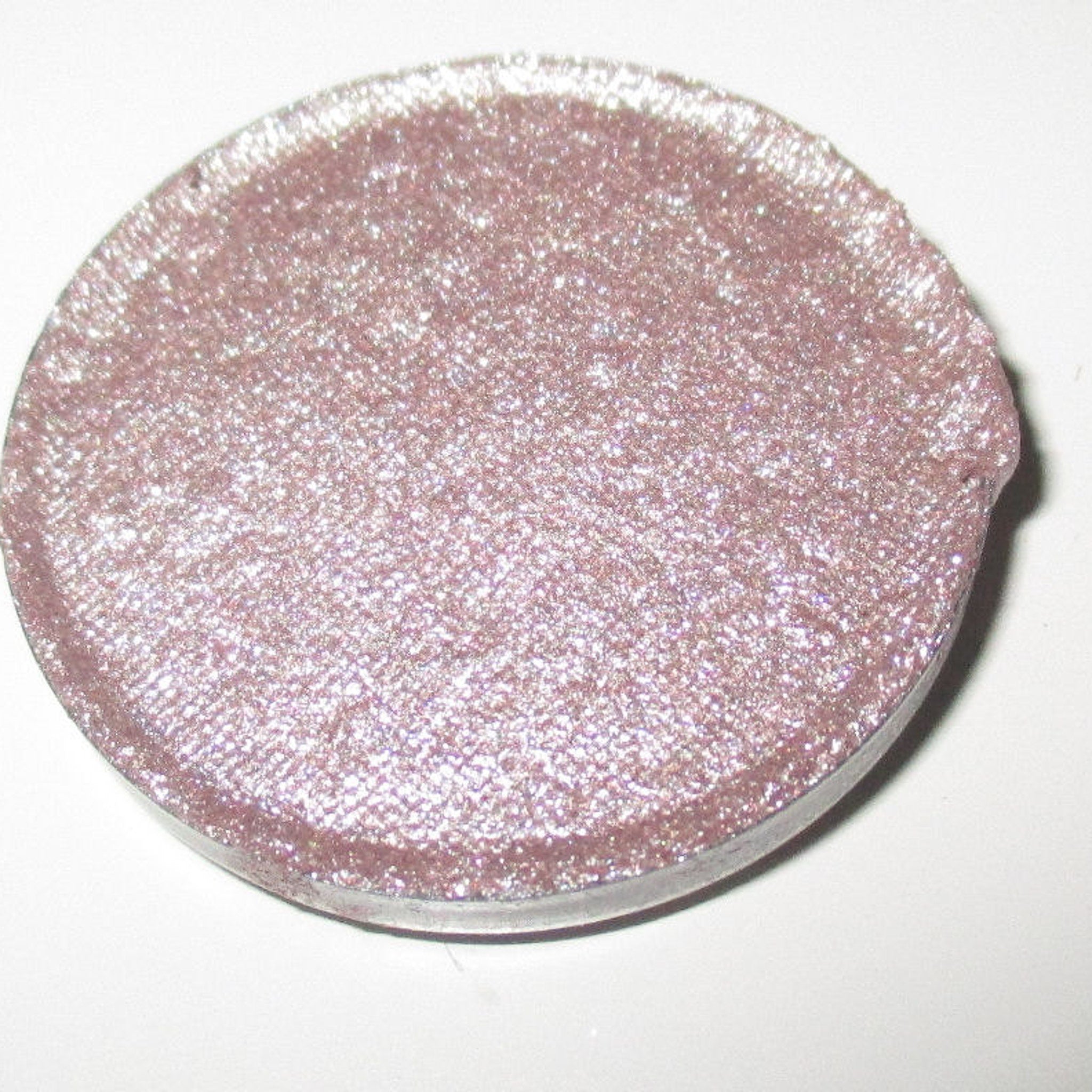Close-up of shimmery Bubbly Eye Shadow in a compact with reflective champagne-toned powder and sleek black case