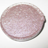 Close-up of shimmery Bubbly Eye Shadow in a compact with reflective champagne-toned powder and sleek black case