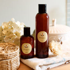 Mia Botanica bottles, brown glass with black cap, organic label, on white towel with flower