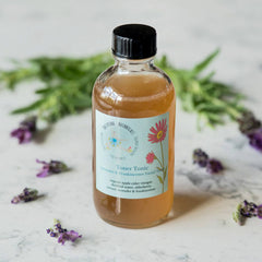 Toner Tonic bottle with black cap, clear glass, and light brown liquid, Ballerina Botanicals label
