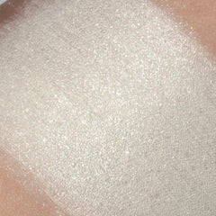 Shimmering eyeshadow swatch, light cream color, textured finish, on skin