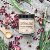 Facial Cleanser jar with black lid, Moonrise Creek label, and dried rose petals on wood surface