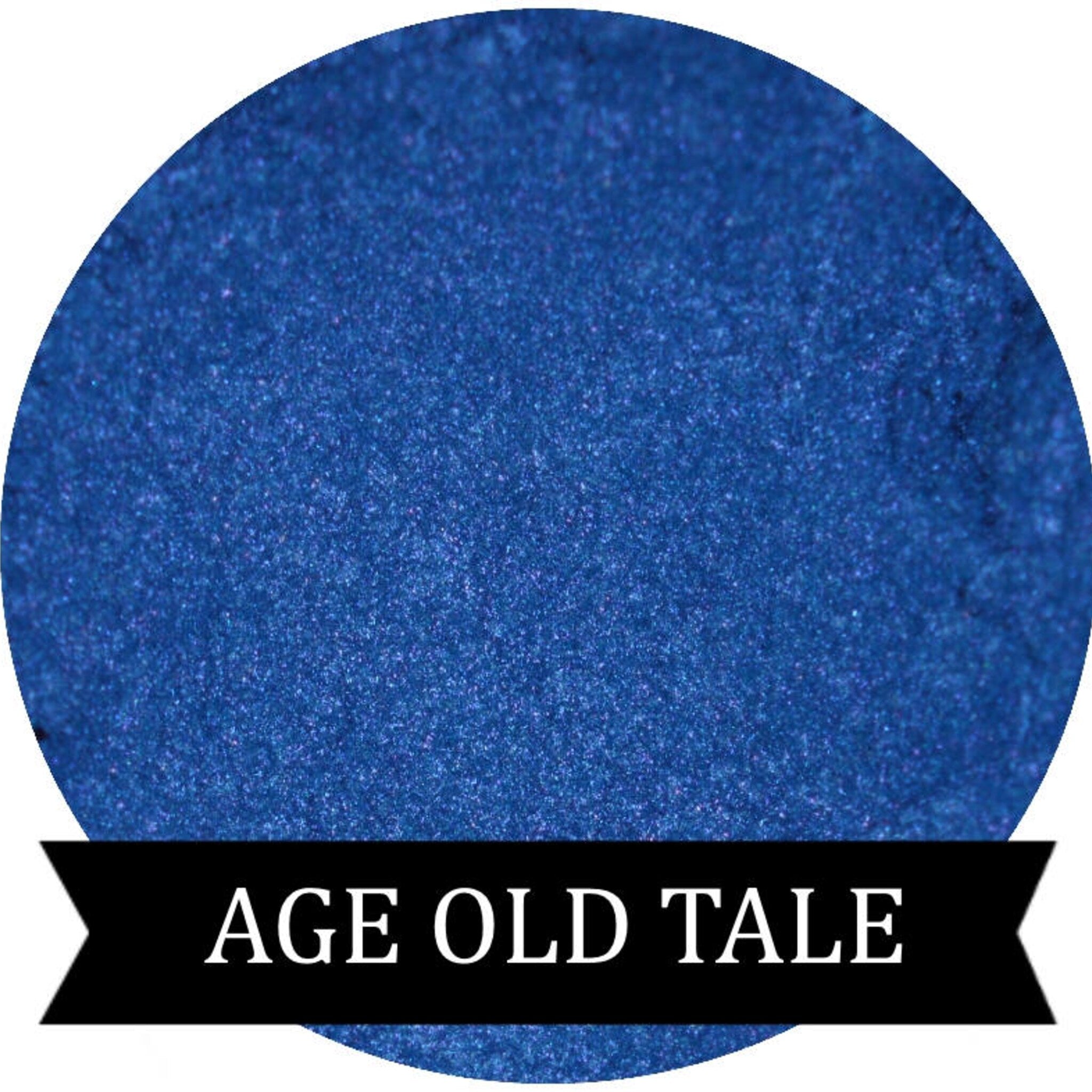 Close-up of vibrant blue powdered eyeshadow in a round black compact with silver detailing