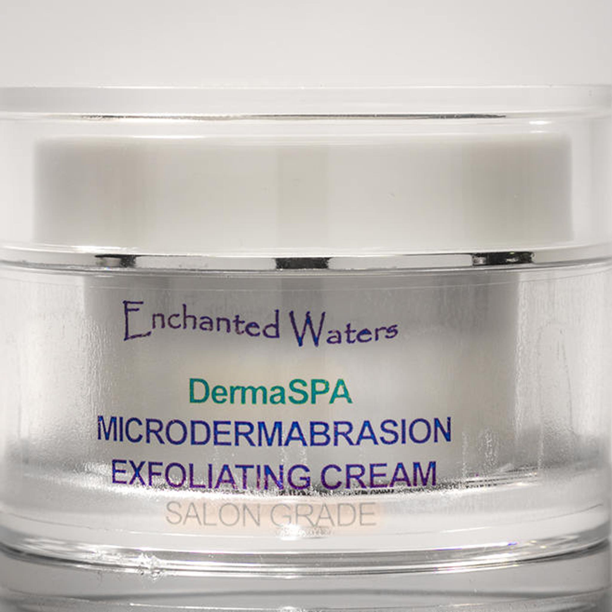 Microdermabrasion cream in clear and white jar with silver trim, Enchanted Waters brand visible