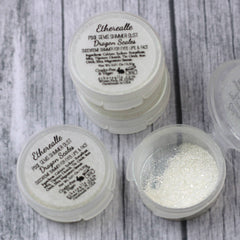 Shimmer dust in white and silver, in clear plastic containers, "Etherealle" brand visible
