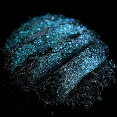 Close-up of iridescent teal eyeshadow with colorshifting glitter in round compact from vegan mermaid collection