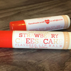 Lip balm tubes in red and white with strawberry cheesecake text and handmade in California label