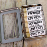 Lip balm set in metal tin with white labels and humorous text on wooden surface