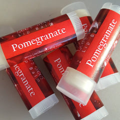 Lip balm tubes with red labels, white text, and clear caps, Lees Bees brand visible