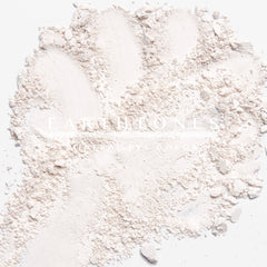 Woman applying soft vanilla mineral eye shadow to eyelid with fingertip for natural makeup look