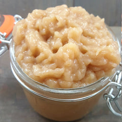 Applesauce in glass jar, light brown color, chunky texture, close-up view