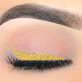 Liquid eyeliner gold metallic applied to eyelid with lashes visible