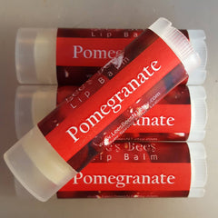 Lip balm tubes with red and white labels, clear plastic cap, and "Pomegranate" text.