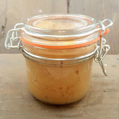 Glass jar with orange seal and silver clasp, filled with light brown substance