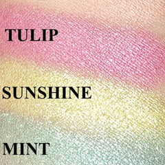 Hand applying mint green eyeshadow with a fluffy brush for a soft spring look