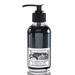 Charcoal gel bottle with black pump, clear glass, and Leaf Seed Berry label showing floral design.