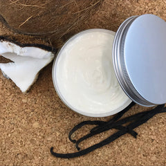 Side view of organic vanilla coconut body butter in a white jar with gold lid, showcasing rich creamy texture