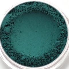 Teal powder pigment with textured surface in a clear container