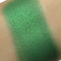 Green eyeshadow swatch with metallic finish on skin, showing texture and color gradient
