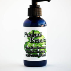 Facial cleanser bottle, dark blue glass, white label, black pump top, Pualani Beauty brand