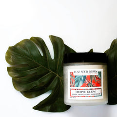 Sugar scrub jar with black lid, white label, and green leaf background