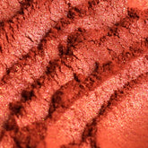 Eye shadow, coral pink duochrome powder, textured surface with glitter flecks