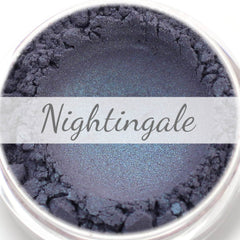 Eyeshadow powder with indigo and turquoise duochrome color, "Nightingale" text visible