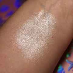 Highlighter swatch with shimmering, light-toned, glittery finish on skin