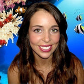 Lipstick on woman with pink lips, brown hair, and smiling face in front of underwater background