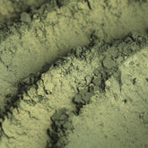 Eyeshadow, green and gold shimmer, textured powder with visible sparkle