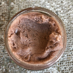 Body scrub in glass jar, brown and pink, textured, top-down view