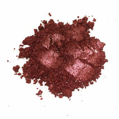 Loose eyeshadow, reddish-brown glittery powder, close-up view on white background