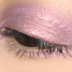 Eyeshadow with shimmering pink color and visible sparkles applied to eyelid