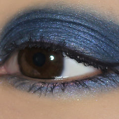 Eyeshadow with dark blue, glitter, and applied to eyelids