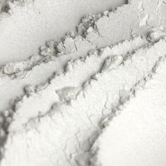 Close-up of shimmery white mineral eyeshadow with fine sparkles in a sample jar