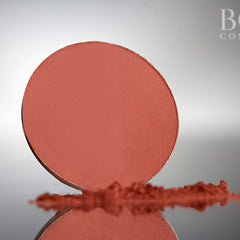 Close-up of deep red wine matte eyeshadow in circular pan showing rich pigmentation and smooth texture