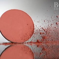Side view of deep red wine matte eyeshadow pan showing pressed powder texture and circular shape