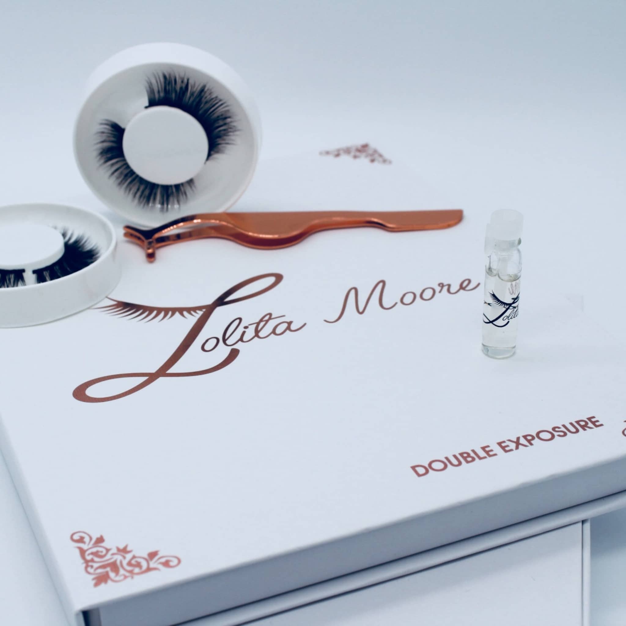 False eyelashes kit with black lashes, white case, and Lolita Moore branding