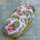 Reusable cotton facial rounds with pineapple print, white stitching, and visible Rocky Mountain Herbs logo