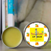 Lip balm tin with yellow balm, silver metal, and mango design with Miss Kinslee's text